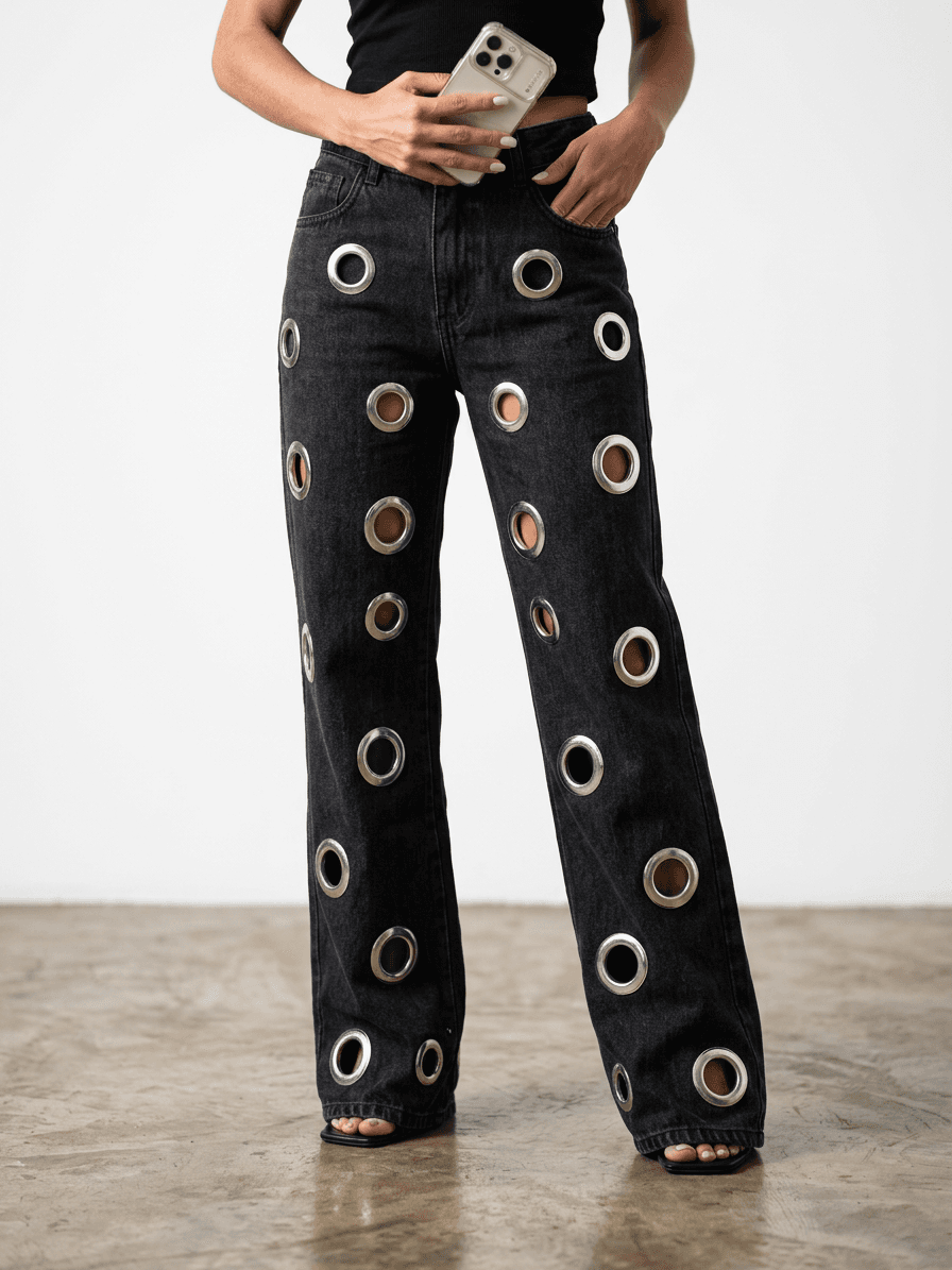 Close da calca wide leg grommet destacando o denim e as ferragens.